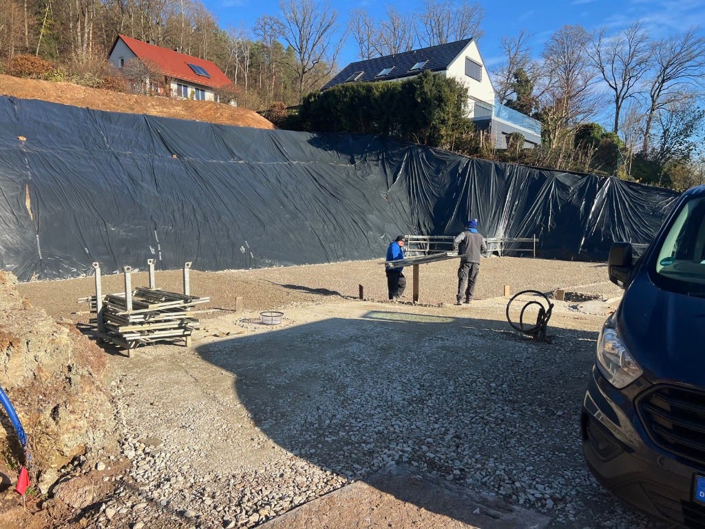 Verbau mit Folie und geschotterte Sohle auf der Baugrube Bierweg 8, November 2025